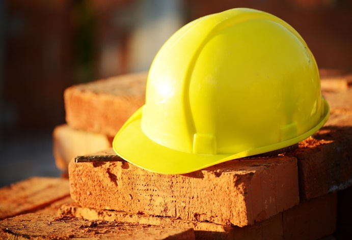 construction-hat-laying-across-bricks