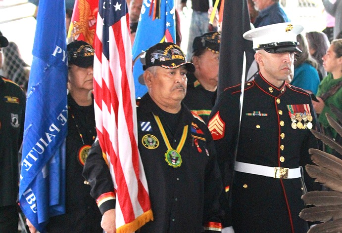 Native Veterans with flags in military attire